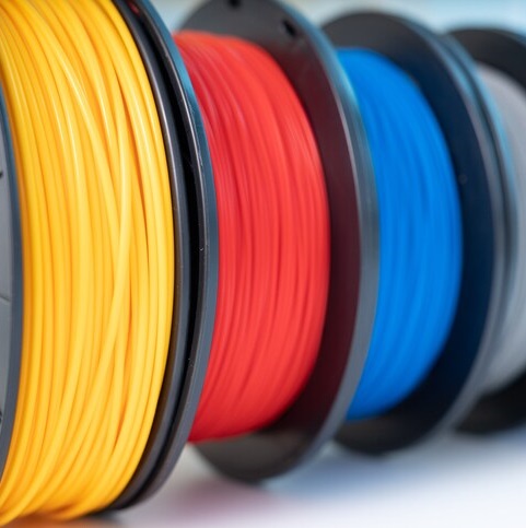 Multiple colors of 3d printing filament spools lined up in a row